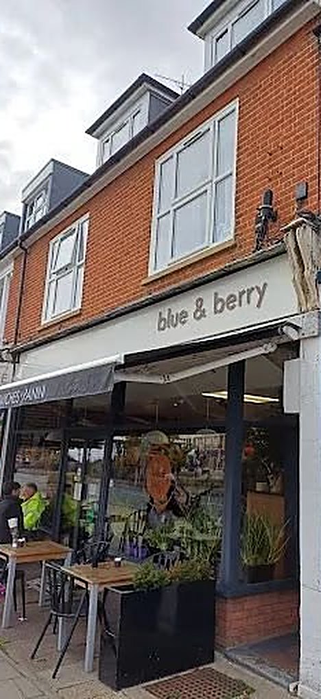 The Blue & Berry shopfront on Hamilton Road: a red-brick building, a white sign reading blue & berry, a grey awning, and tables and planters on the pavement